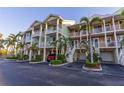 Condo complex exterior featuring private garages, stairways, and manicured landscaping at 3210 Mangrove Point Dr, Ruskin, FL 33570