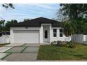 Charming single-Gathering home with white exterior, well-maintained landscaping, and a two-car garage at 3422 E Powhatan Ave, Tampa, FL 33610