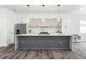 Modern kitchen featuring white cabinets, stainless steel appliances, and a stylish center island at 3422 E Powhatan Ave, Tampa, FL 33610