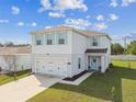 Charming two-story home boasts a two-car garage and lovely light blue shutters, set in a well-maintained lawn at 35168 Arya Way, Zephyrhills, FL 33541