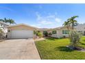 Well-maintained single-story home featuring a clean facade, attached garage, and a beautifully landscaped front yard at 4544 Harbor Hills Dr, Largo, FL 33770