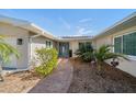 Inviting entrance with brick walkway and lush landscaping leading to a charming blue front door at 4544 Harbor Hills Dr, Largo, FL 33770