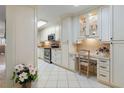 Well-lit kitchen with white cabinets, tile flooring, and a built-in desk area at 6021 Bahia Del Mar Cir # 137, St Petersburg, FL 33715