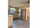 Well-lit kitchen featuring stainless steel refrigerator, neutral countertops and cabinets, and modern fixtures at 6420 N Thatcher Ave, Tampa, FL 33614
