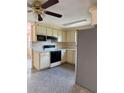 Traditional kitchen with white cabinetry, black appliances, and speckled flooring creating a functional space at 6420 N Thatcher Ave, Tampa, FL 33614