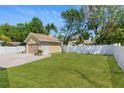 A well-maintained backyard with lush green grass and a white fence providing privacy at 7701 N Dartmouth Ave, Tampa, FL 33604