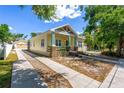 This charming home features a long driveway leading to a detached garage, surrounded by lush greenery at 7701 N Dartmouth Ave, Tampa, FL 33604