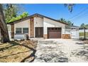 Charming single-story home with stone accents, a two-car garage, and a well-maintained front yard at 8902 N Hamner Ave, Tampa, FL 33604