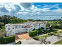 Beautiful home with a clay tile roof, three-car garage, and lush landscaping at 1102 Palm View Ave, Belleair, FL 33756