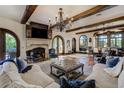 Elegant living room with a stone fireplace, wooden beams, and designer furnishings at 1102 Palm View Ave, Belleair, FL 33756