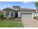 Charming home with a tiled roof, well-maintained landscaping, and a brick paver driveway at 11414 Juglans Dr, Odessa, FL 33556