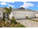 Charming home exterior featuring a tile roof, stone accents, paved driveway, and fresh landscaping at 12323 Hearts Ease St, Venice, FL 34293