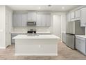 Modern kitchen with stainless steel appliances, quartz countertops, a spacious island, and stylish cabinetry at 12323 Hearts Ease St, Venice, FL 34293