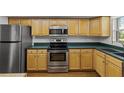 Well-lit kitchen with stainless steel appliances and wood cabinetry at 131 Bluff View Dr # 101, Belleair Bluffs, FL 33770