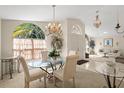 Formal dining room featuring a glass table, decorative chandelier, and arched window with natural light at 15014 Arbor Hollow Dr, Odessa, FL 33556