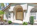 Inviting front entrance featuring an arched doorway, double doors, and decorative window with decorative columns at 15014 Arbor Hollow Dr, Odessa, FL 33556