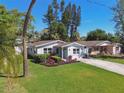 Quaint single-story house features manicured landscaping, bright shutters, and a large, green lawn at 1775 Michigan Ne Ave, St Petersburg, FL 33703