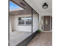 Inviting screened entryway leading to a front door with decorative glass and tiled floor at 2214 Wilshire Dr, Dunedin, FL 34698
