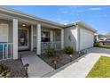 Inviting front porch with seating, decorative plants, and a well-lit walkway leading to the front door at 29408 Princeville Dr, San Antonio, FL 33576