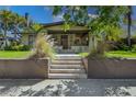 Charming home featuring a welcoming front porch, well-manicured lawn, and inviting front steps leading to the entrance at 307 Bay St, Tarpon Springs, FL 34689