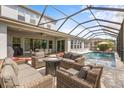 Relaxing outdoor living space with a pool, screened enclosure, and comfortable seating at 32203 Wenlock Loop, Wesley Chapel, FL 33543