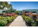 The front entrance of the condo is beautifully landscaped with colorful foliage leading to the welcoming entrance at 36750 Us 19 N Hwy # 18-210, Palm Harbor, FL 34684