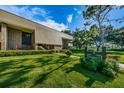 A two-story condo building with attractive landscaping and signage showing the building address at 36750 Us 19 N Hwy # 18-210, Palm Harbor, FL 34684