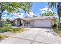 Well-kept single-story home with stone facade, green lawn, and driveway leading to a two-car garage at 4110 Summerdale Dr, Tampa, FL 33624