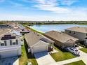 Aerial view showcasing a neighborhood with lake views, well-kept lawns, and modern homes at 659 Sunlit Coral St, Ruskin, FL 33570