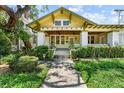 Inviting home featuring mature landscaping and a covered front porch with ceiling fans at 701 S Boulevard, Tampa, FL 33606