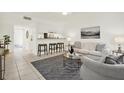 Bright living room featuring a neutral color palette, bar-style seating, and tile flooring at 7645 Sun Island S Dr # 204, South Pasadena, FL 33707