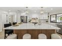 Bright kitchen with a large center island, stainless steel appliances, white cabinets, and modern pendant lighting at 9807 Bay Island Dr, Tampa, FL 33615