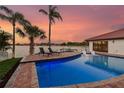 Beautiful pool overlooking the bay at sunset, complete with lounge chairs and a picturesque view at 9807 Bay Island Dr, Tampa, FL 33615