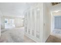 Bright hallway with mirrors, leading to carpeted living spaces and bedrooms at 1218 Haddington Cir, Sun City Center, FL 33573