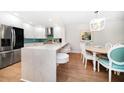 Open-concept kitchen with white cabinets, breakfast bar, stainless steel appliances, and adjacent dining area at 14810 Rue De Bayonne # 2D, Clearwater, FL 33762