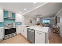 Bright kitchen features white cabinets, stainless steel appliances, quartz countertops, and an eat-in area at 14810 Rue De Bayonne # 2D, Clearwater, FL 33762