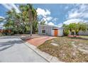 Cozy single-story home with a spacious driveway, orange door, and desert landscaping for easy maintenance at 157 7Th Sw Ave, Largo, FL 33770