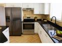 Modern kitchen featuring stainless steel appliances, granite countertops, and double sink at 1741 Fairfield St, Holiday, FL 34691