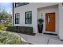 A modern front door with sidelight, contrasted with verdant landscaping, provides an inviting entrance at 2511 N Grady Ave # 82, Tampa, FL 33607