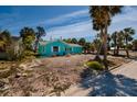 A single-story home with light blue exterior, complemented by mature palm trees in the yard at 340 83Rd Ave, St Pete Beach, FL 33706