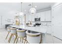 Bright kitchen features an island with quartz counters, pendant lighting and stainless steel appliances at 3706 Front Park Dr, Wesley Chapel, FL 33543