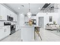 Open kitchen showcasing white cabinetry, stainless steel appliances and a large island with counter seating at 3706 Front Park Dr, Wesley Chapel, FL 33543