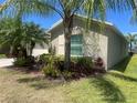 Well-maintained home featuring manicured landscaping and mature palm trees at 4908 Babbling Brook Ln, Wimauma, FL 33598