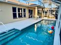 A pristine pool with crystal-clear water, surrounded by a screened enclosure, and a clean white patio, perfect for relaxation at 4942 Oldham St, Sarasota, FL 34238