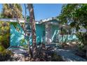 Charming aqua home featuring a quaint front porch with decorative metal supports at 515 77Th Ave, St Pete Beach, FL 33706