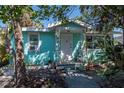 Charming aqua home featuring a quaint front porch with decorative metal supports at 515 77Th Ave, St Pete Beach, FL 33706