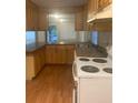 Functional kitchen features wooden cabinets and a white electric range at 6200 N 44Th St, Tampa, FL 33610