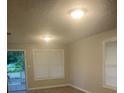 Well-lit living room with two windows, neutral walls, and a rear entrance door at 6200 N 44Th St, Tampa, FL 33610