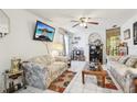 Cozy living room featuring a ceiling fan, wall-mounted TV, and comfortable, patterned sofas at 6544 S West Shore Cir, Tampa, FL 33616