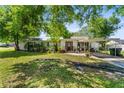 Single-story home with a covered parking area, featuring a well-maintained lawn and traditional design at 7110 N Rome Ave, Tampa, FL 33604